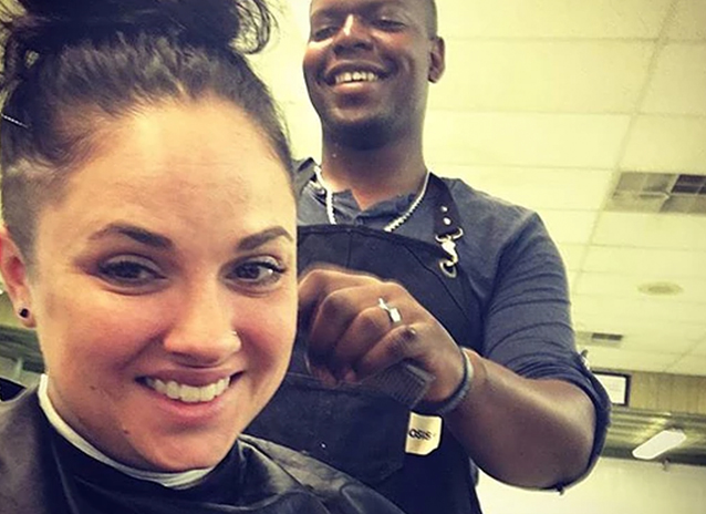 A barber cutting hair of a woman